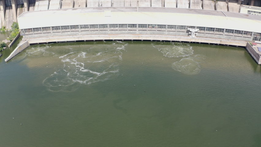 The beautiful river is surrounded by green and fresh vegetation in the city. Dnieper hydroelectric power station in Zaporozhye