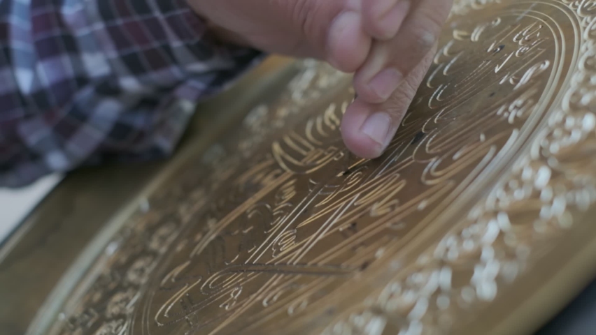 Bukhara master engraves patterns on a tray. Close up, slow motion Royalty-Free Stock Footage #1062110263
