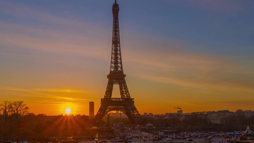 4K timelapse of Paris at sunrise with the Eiffel Tower at the Trocadero gardens and the traffic,the most famous landmark in Paris,France.Golden hour in an autumn winter sunny day in 