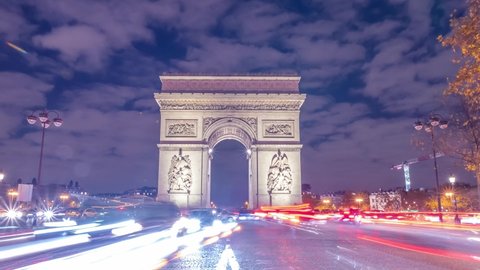 4K Timelapse of traffic at Arc de Triomph at night in an autumn winter day. This historical monument overlooks the avenue des champs élysées in the heart of Paris, French capital. 