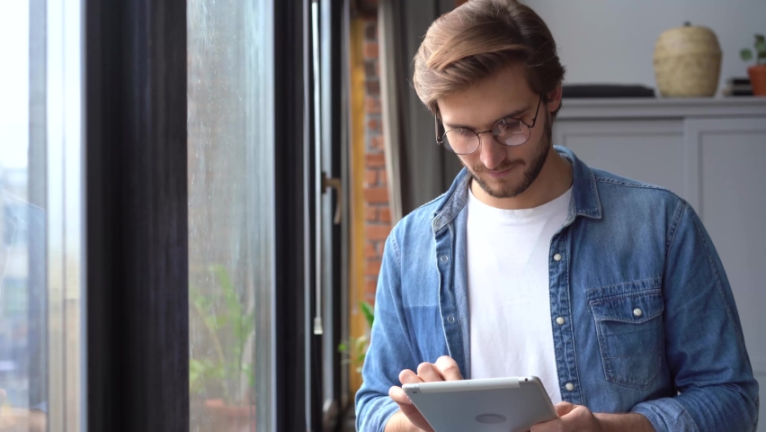 Young professional man worker using digital tablet standing at home office Royalty-Free Stock Footage #1062114976
