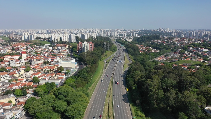Aerial landscape of freeway near city. Skyline city landscape. Panorama landscape of highway around cityscape, Sao Paulo. Brazilian city. Brazilian landmark.  Bandeirantes road aerial view, Sao Paulo.