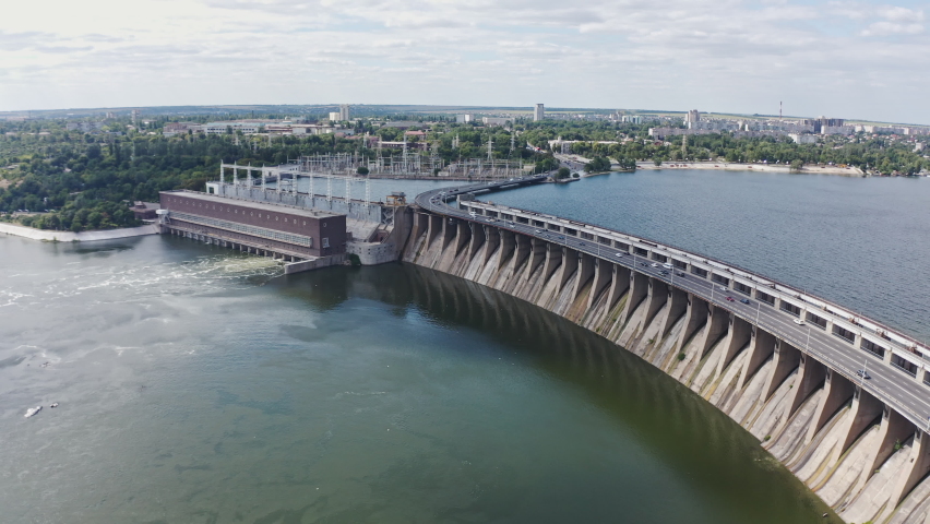 The beautiful river is surrounded by green and fresh vegetation in the city. Dnieper hydroelectric power station in Zaporozhye