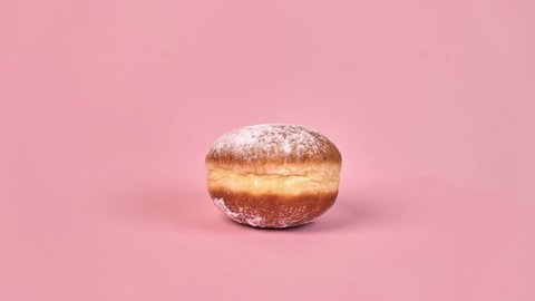 Stop motion sweet doughnut with filling. Half-eaten food., in the context of. On a pink background.