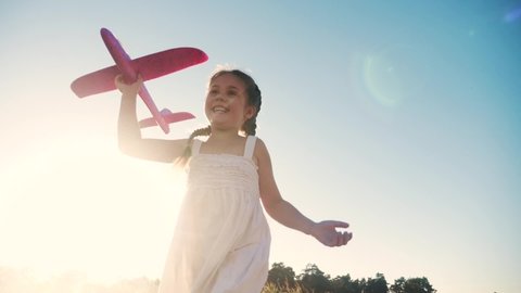happy girl child run with an airplane. kid silhouette play plane. happy family dream freedom airplane concept. daughter kid run on wheat field at sunset holds in his hands dream fun aircraft toy