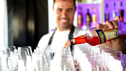 Barcelona, Spain, October 27, 2020: Barman pouring Aperol, an italian alcoholic drink for a cocktail with Codorniu Raventos in a spanish night club