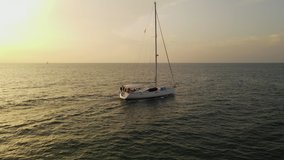 Drone video of a yacht crossing the water at sunset. High quality 4k footage