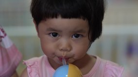 Footage of close up cute asian baby drinking water