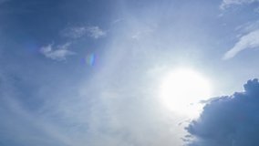 Timelapse video of blue sky clouds and sun in winter season. Dark clouds moving under bright sunlight. Sun beam shine over clear space in atmosphere.  Skycaps nature background footage. 