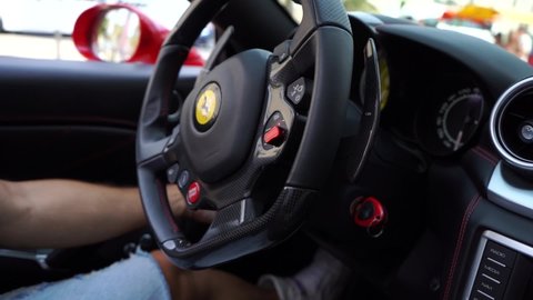 Barcelona , Catalonia / Spain - 09 01 2019: Close Up Slowmotion View on Male Hand With Tattoo on Ferrari Sports Car Steering Wheel