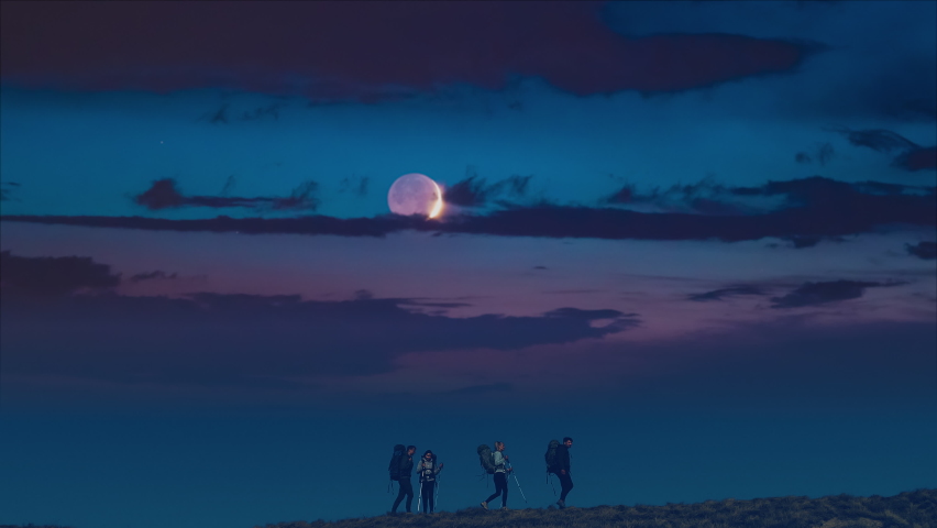 The four tourists are walking on the scenic night sky background