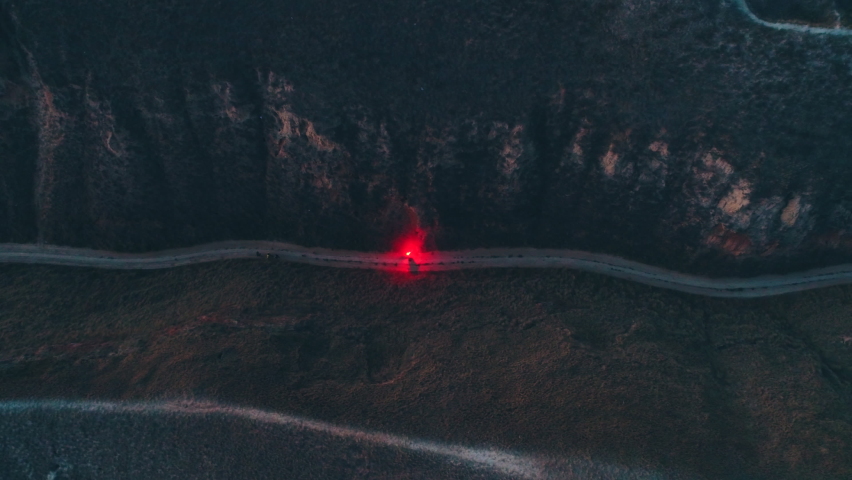 The man with a flaming torch is running in the mountains