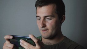 man playing phone on gray background