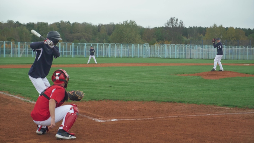 College sports, guys play baseball, the pitcher throws the ball towards the batter, batter successfully hits the fastball and run to base.