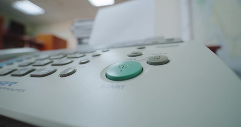 Hand of a woman using fax, presses the button and picks up the phone, Close up.