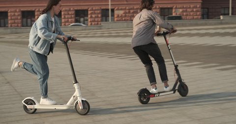 Couple enjoying riding electric scooter in city