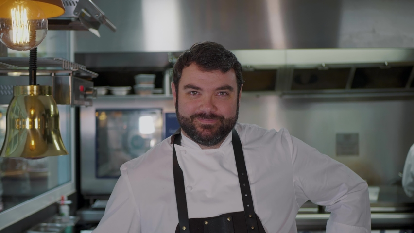 Smiling male Chef cook portrait in restaurant's commercial industry kitchen zoom out  Royalty-Free Stock Footage #1062161143