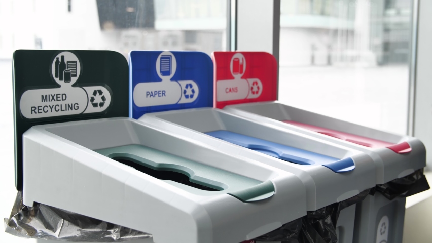 Close up of trash bins of different color for recycling different materials. Media. Man hand throwing plastic empty bottle in recycling bin, concept of ecology, waste separation point for plastic | Shutterstock HD Video #1062163930