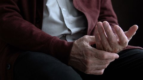 Aged man feeling pain in hand, inflammation of joints, rheumatoid arthritis