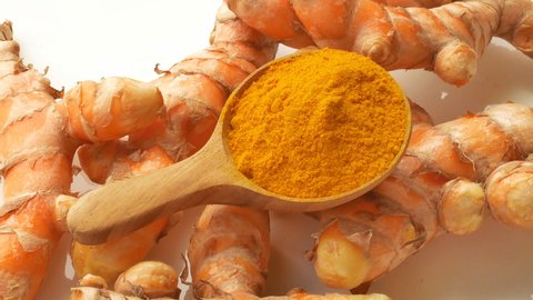 Turmeric and Turmeric powder in a wooden spoon Rotation