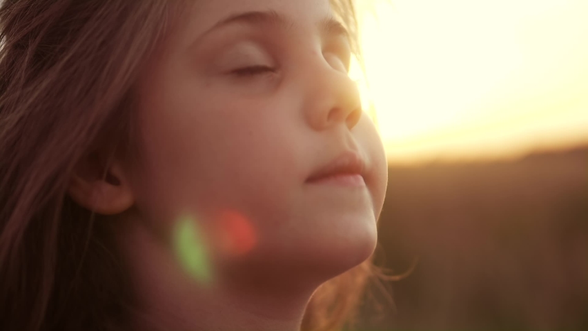 Happy little girl child looking up eyes dream. kid wants a dream come true portrait at sunset. baby daughter look up silhouette dreaming of a happy childhood. kid free face sister side view thinks