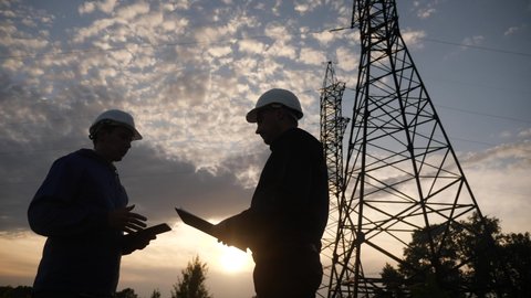 teamwork. two electricians engineer shake hands. business partnership energy technology industry a concept. silhouette two workers handshake. teamwork lifestyle in energy