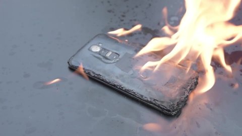 Mobile phone explodes and burns. Cell Phone explosion and fire .Smart Phone Danger from over use or bad manufacturing. Burning up my phone concept.