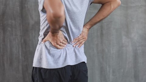 young man suffering from back pain, have a backache, health problems