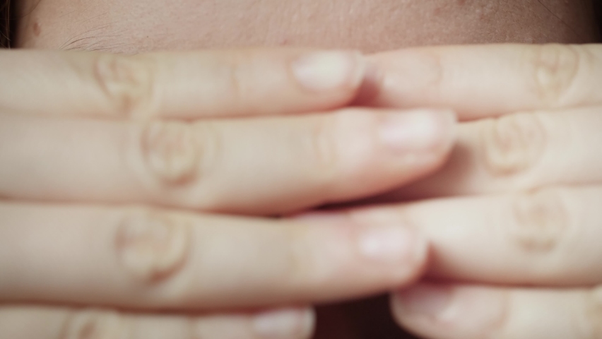 Close up of Woman covering face with hands and revealing beautiful blue eyes. Young female model with natural make-up and long eyelashes looking at camera. Slow-motion, macro extreme close-up, 4K.