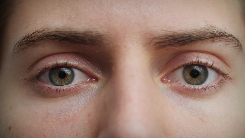 Close up of Man's face. Attractive boy opening his blue eyes in fear. Concept of shock, terror, horror. Male model with pretty blue, green, grey eyes. Slow-motion, macro extreme close-up, 4K. Royalty-Free Stock Footage #1062187876