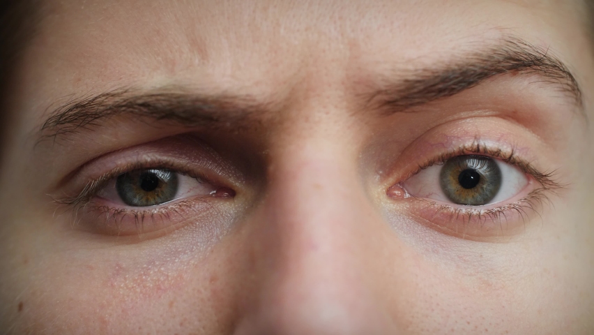 Close up of Man's face raising eyebrow. Boy with blue eyes looking at camera. Concept of skepticism, wonder. Male model with pretty blue, green, grey eyes. Slow-motion, macro extreme close-up, 4K. | Shutterstock HD Video #1062187885
