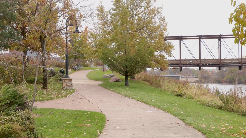Beautiful park trail by the river. People walking in the Phoenix Park in Eau Claire Wisconsin