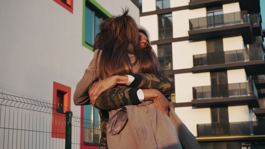 Emotional afro american man hugging and kissing his charming young girlfriend during sunny day on street. Young couple meeting on fresh air. Concept of relationship. | Shutterstock HD Video #1062196186