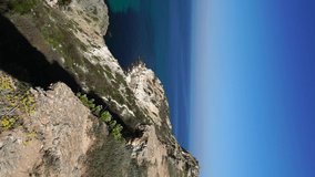 Baunty beach on cape Fiolent in Balaklava, Sevastopol. View from the top of the rock. azure sea, sunny day clear sky background. The concept of perfect place for summer travel and rest. Vertical video