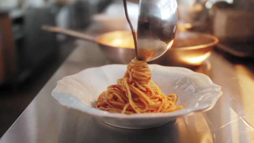 Chef cooking and serving bolognese fresh pasta with tomato sause, man making traditional italian dinner on restaurant kitchen, tasty food, high haute kitchen  Royalty-Free Stock Footage #1062199753