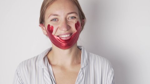 A woman blogger tells live about the novelties of caring for a face, pulling up a mask for the chin.