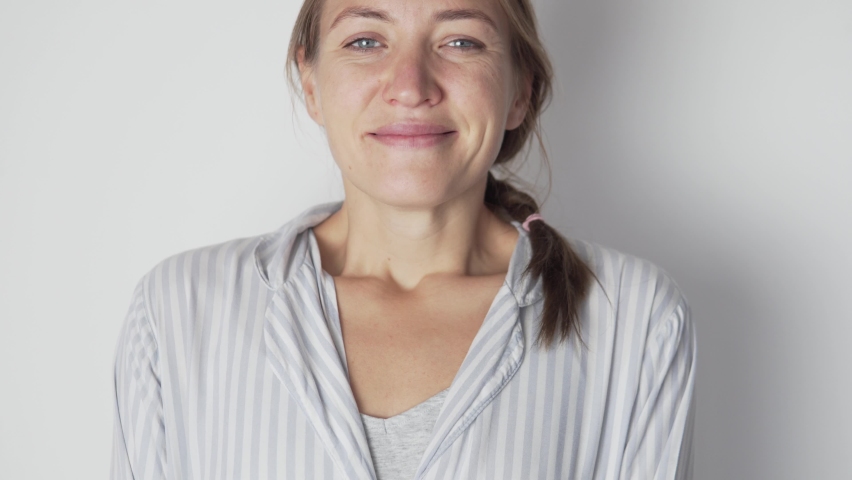 Close-up of the face, a happy young woman without makeup in the morning.