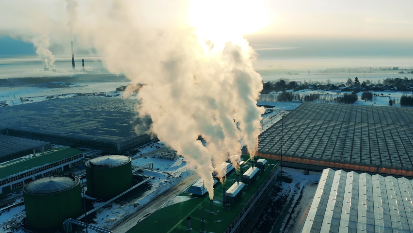 Smoke is billowing from the factory chimneys in a top view