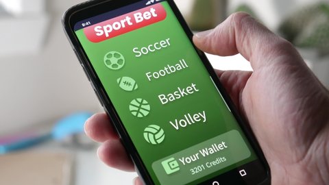 Placing a sports bet online on a smartphone app. Choosing which team will win and betting online. Gambling money on Internet.