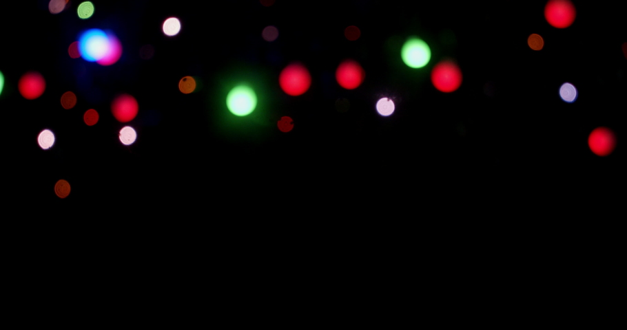 The Christmas lights of the garland sparkle brightly. On a black background.