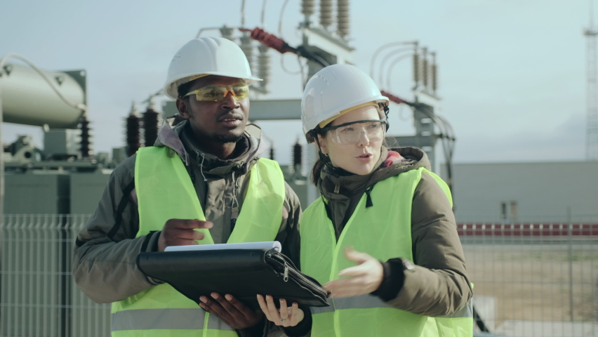 African-American power electrical substation worker and skilled construction engineer lady discuss project perspectives closeup | Shutterstock HD Video #1062206749