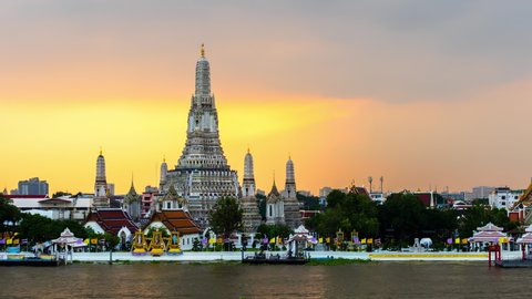 day to night time lapse of Wat Arun Temple with Chao Phraya river in Bangkok, Thailand