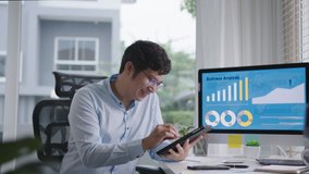 Portrait head shot of young attractive asian man sitting smiling work multiple screen computer and smart tablet on table desk at home in concept freelance data analyst, data scientist for business. - Powered by Shutterstock - Get 15% off with code: PIKWIZARD15