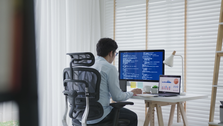 Back rear view of young asian man, freelance data scientist work remotely at home coding programing on Big data mining, AI data engineering, IT Technician Works on Artificial Intelligence Project. | Shutterstock HD Video #1062211534