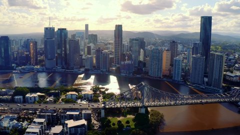 Cars Travelling At Story Bridge Spanning Brisbane River With Brisbane CBD At Sunset In Background In Queensland, Australia. - aerial