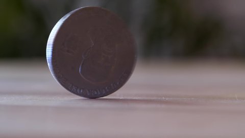 50 cent coin spinning on wooden table, macro close up
