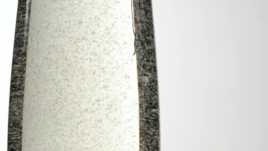 Jet Of Champagne Of Carbonated Drink Or An Alcoholic Cocktail Is Poured Into Glass On A White Background. Concept Of Tasting Alcoholic And Non-alcoholic Beverages In Cafes Bars And Restaurants