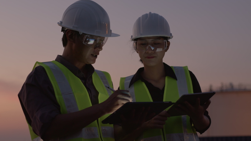 two Asian engineer using a digital tablet at the petroleum oil refinery in night shift Royalty-Free Stock Footage #1062218068