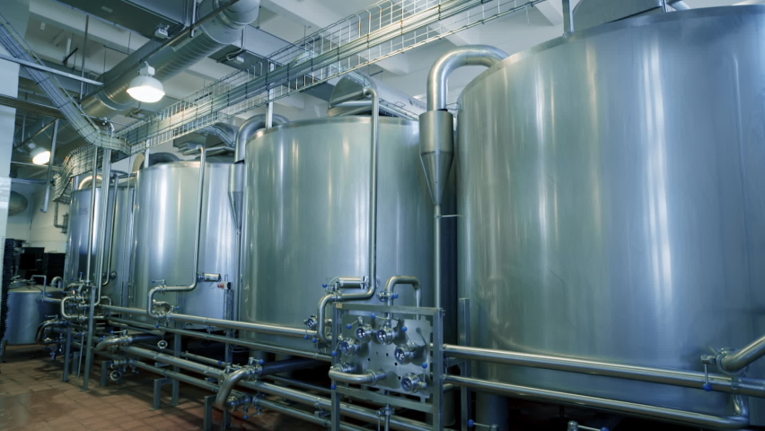 Modern plant for the production of dairy products. Milk is normalized and sterilized in Steel tanks. Containers. Automated line in a modern factory. No people needed. Wide shot.