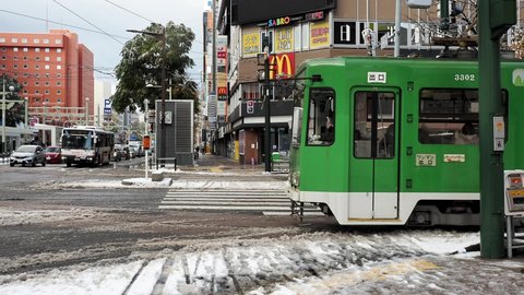 Hokkaido,Japan-November 11, 2020: A tramcar running Susukino intersection in Sapporo city in the snowy morning
